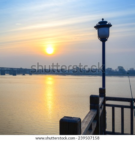 Yalu River Bridge at morning. In the distance is North Korea. Located in Yalu River Scenic Areas of Dandong City, Liaoning province, China.