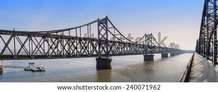 Yalu River Bridge at morning. In the distance is North Korea. Located in Dandong City, Liaoning province, China.