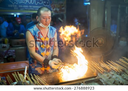 Shenyang, China - May 10, 2015: Chinese chef making Fire Iron Squid. Located in Xingshun International Tourist Night Market, Shenyang City, Liaoning province, China.