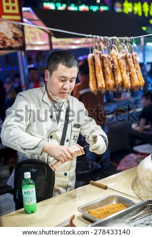 Shenyang, China - May 10, 2015: Chinese chef selling Barbecue. Located in Xingshun International Tourist Night Market, Shenyang City, Liaoning province, China.