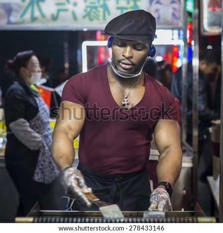 Shenyang, China - May 10, 2015:  African American chef is cooking. Located in Xingshun International Tourist Night Market, Shenyang City, Liaoning province, China.