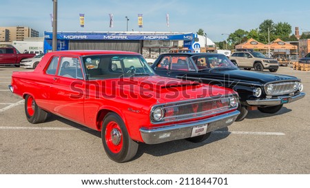 ROYAL OAK, MI/USA - AUGUST 15, 2014: A 1965 Dodge Coronet and a 1962 Dodge Dart at the Woodward Dream Cruise, the world\'s largest one-day automotive event. Woodward is a National Scenic Byway.