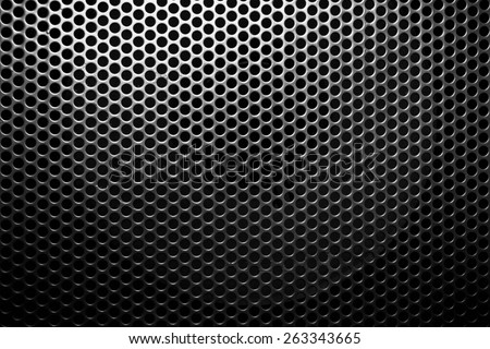 Metal mesh with round black holes close up.