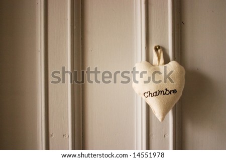 A bedroom door with the french word chambre (which means bedroom) embroidered on a heart
