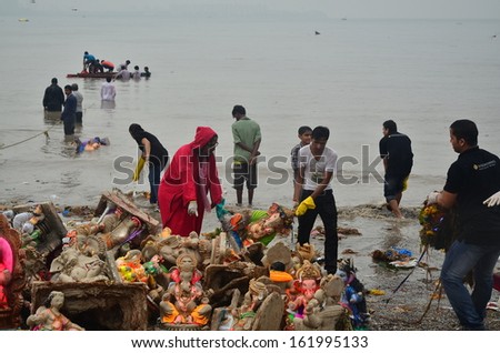 Mumbai, India - circa September 2013 - Volunteers helping to clean up the beach during the rain after the immersion of Hindu God Ganesha
