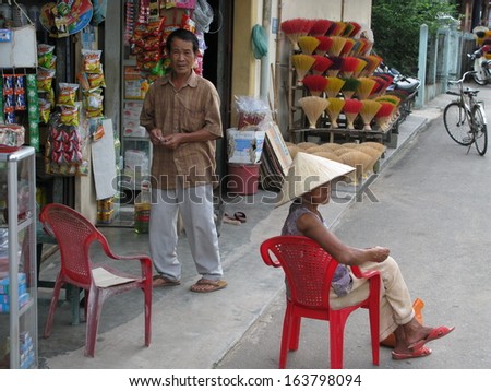 Hue, Vietnam - May 2009 - Shop keepers selling bundles of incense sticks shaping like blooming flowers
