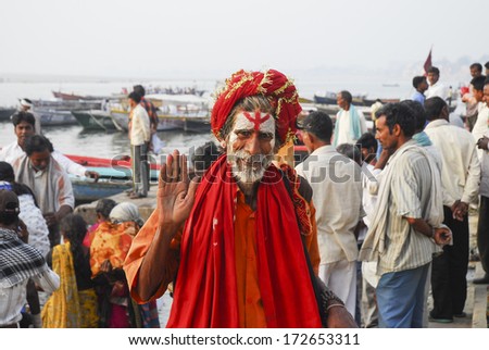 Varanasi, India - April 8, 2012 - Hindu holyman at pier with people at background  at the Ghat of Ganga river in holy city of Varanasi