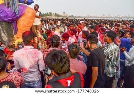 MUMBAI, INDIA - SEPT 17, 2013 - Devotees worshipping praying before bringing Hindu God Ganesha into the ocean during Ganesha Festival