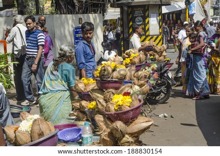 Mumbai, India - February 21,  2014 -  Vendors selling flowers,  garlands snd coconuts along the street in front of Hindu temple during daytime