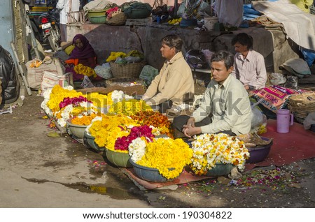 Jaipur, India - February 27, 2014 - Vendors selling fresh flowers and garlands at local market of Jaipur during bright sunny day