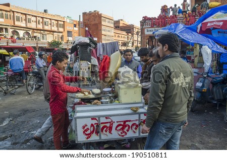 Jaipur, India - February 27, 2014 - Street vendor preparing food and snack to customers at local market during daytime