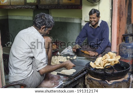 Jaipur, India - February 27, 2014 - Street food vendor preparing and selling meal and snack  for customers at local market during daytime