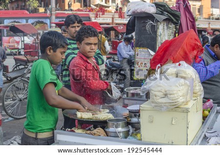 Jaipur, India - February 27, 2014 - Street food vendor preparing meal and snack for customers at local market during daytime