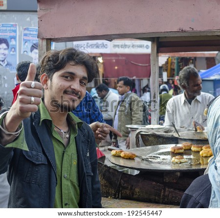 Jaipur, India - February 27, 2014 - Street food vendor greeting while preparing meal and snack for customers at local market during daytime