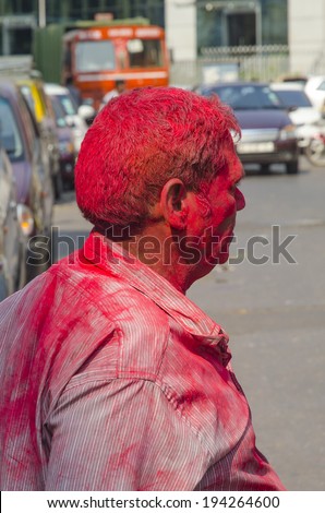 Mumbai, India - March 16, 2014 - Old man with colors on his face celebrating Holi Festival of colors near Gateway of India in Mumbai