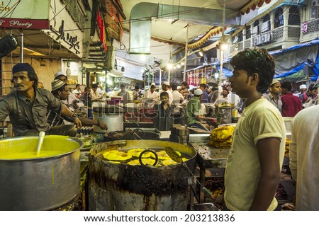 Mumbai, India - July 3, 2014 -  Men frying snack in hot oil pan from stall at at crowded Mohammad Ali Road in the evening during Ramzan fasting month