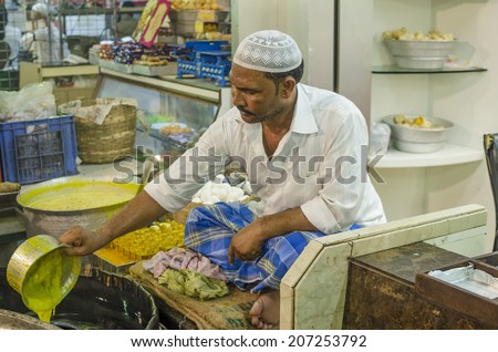 Mumbai, India - July 3, 2014 -  Muslim man frying snack in hot oil pan from stall at crowded Mohammad Ali Road in the evening during Ramzan fasting month