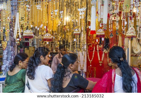 Mumbai, India - August 22, 2014 - People buying artificial flowers and garlands and gold ornament at shop at local market