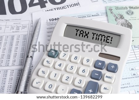 Tax Forms and Check with Calculator that spells out TAX TIME on the display