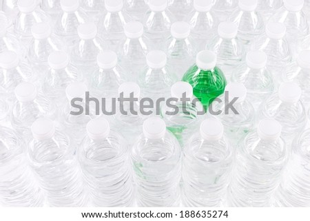 Front View of Staggered Plastic Water Bottles with One that has Green Colored Contents