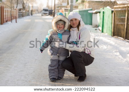 mother with the son stopped on the snow-covered road