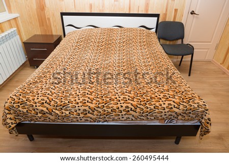 the big bed is made by a cover costs in the room