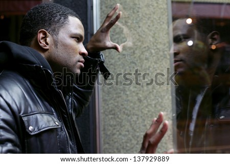 Man looking at reflection in shop window
