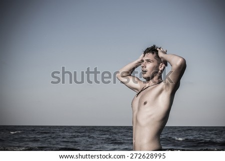Attractive young man in the sea getting out of water with wet hair