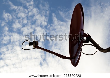 silhouette of red television satellite dish with blue sky and cloud