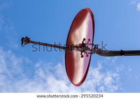 silhouette of red television satellite dish with blue sky and cloud
