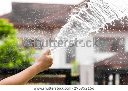 water motion created by rubber tube with blurry house background