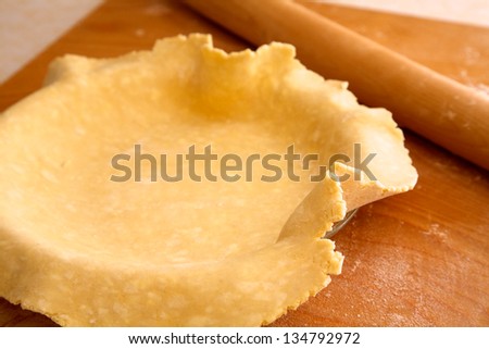 Homemade pie crust, flecks of butter visible, rolled out and ready to be fit into pie plate