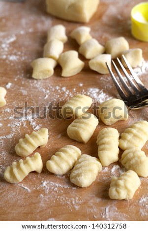 Gnocchi, or potato pasta, homemade on floured board with fork, vertical