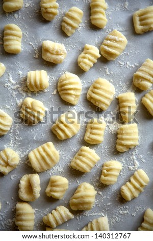 Homemade gnocchi, or potato pasta, on floured parchment paper, ready to cook