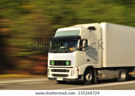 Fast moving white truck, motion blur