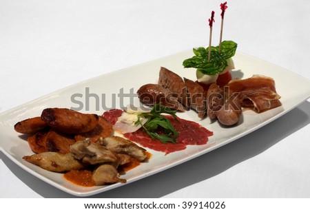 An Entree selection plate offering Roasted Quail, Italian Sausages, Beef Carpaccio, Prosciutto, Tomato, and Bocconcini