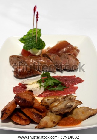 An Entree selection plate offering Roasted Quail, Italian Sausages, Beef Carpaccio, Prosciutto, Tomato, and Bocconcini