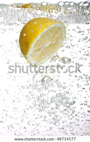 lemon falls into water on a white background