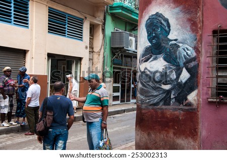 HAVANA, CUBA - JANUARY 1, 2014: People chatting on the street of Old Havana in Havana, Cuba. Old Havana is the city-center and one of the 15 municipalities forming Havana, Cuba