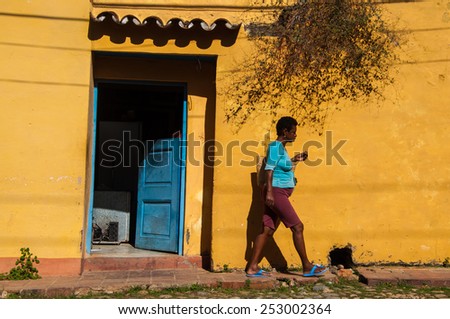 TRINIDAD, CUBA - NOVEMBER 18, 2013: A Cuban woman is walking up the hill in Trinidad, Cuba. Trinidad has been one of UNESCOs World Heritage sites since 1988.