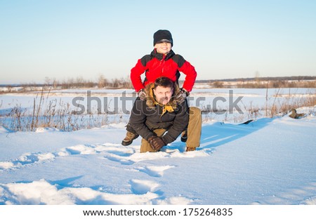 Father and son playing outddors in snow. Happy family.