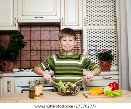 Smiling boy mixing vegetable salad. Healthy Food - Vegetable Salad. Diet.