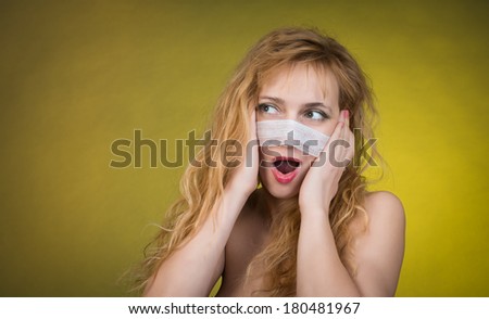 Plastic surgery concept. Woman with bandage on her face on yellow background.