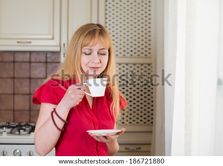 Woman with cup of coffee or tea in the kitchen. Morning coffee.
