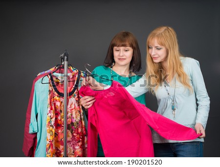Two happy women shopping in clothes store.