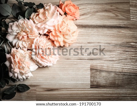 Vintage retro background with roses on wood. Romantic floral frame background.