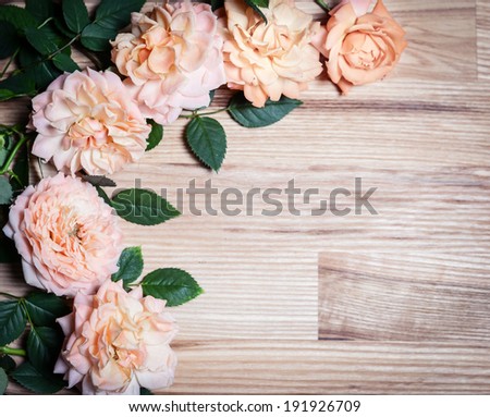 Vintage retro background with roses on wood. Romantic floral frame background.