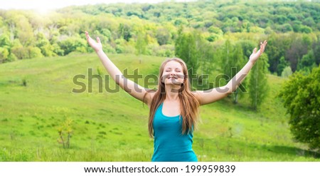 Enjoyment - free happy woman enjoying nature. Girl with arms outspread and face raised in sky enjoying peace, serenity in nature. Happy woman relaxing outdoors with arms open.