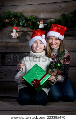 Smiling children with Christmas gift and New Year tree. Making present. Retro styled.