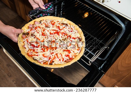 Raw Fresh Homemade Pizza Baking in Electric Oven.